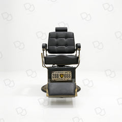 black vintage-style barber chair with quilted padded backrest, adjustable headrest, gold-tone details and footrest