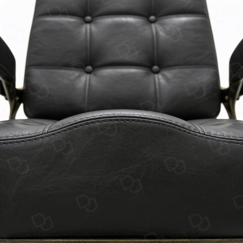 black vintage-style barber chair with quilted padded backrest, adjustable headrest, gold-tone details and footrest
